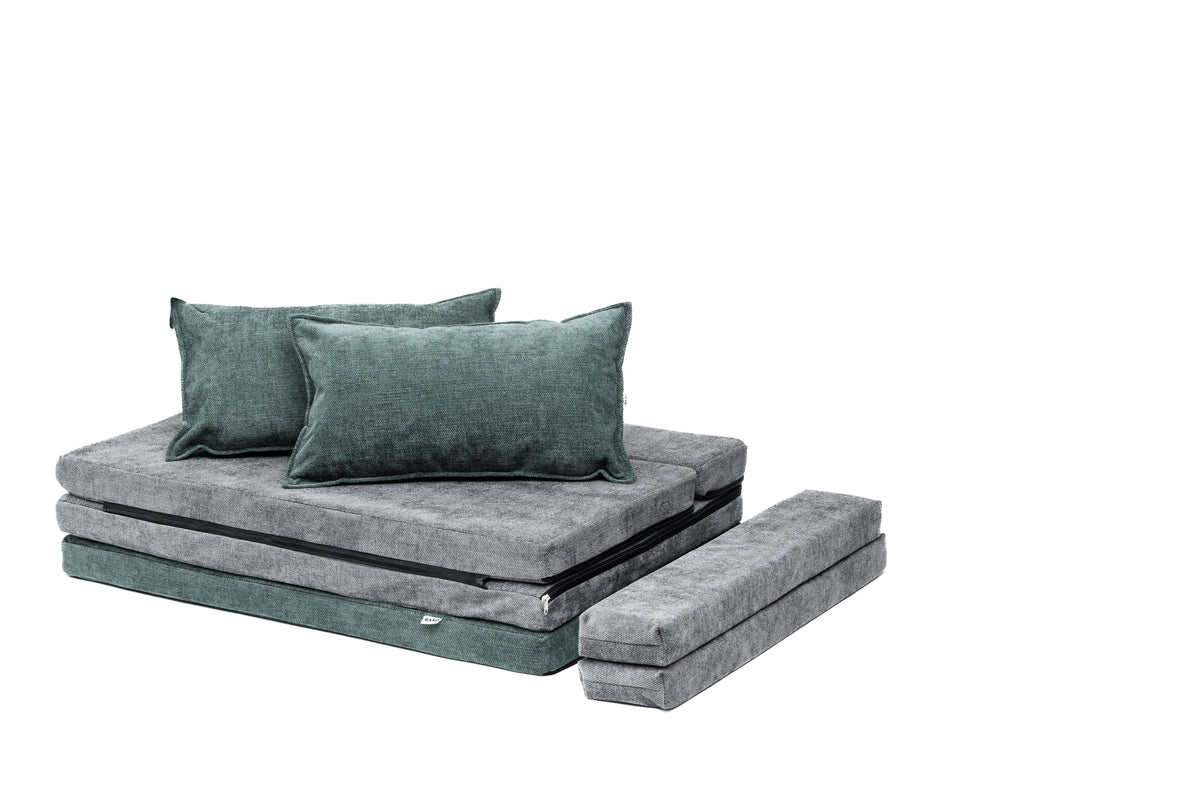 Mørkegrønne og grå puter lagt som sofa